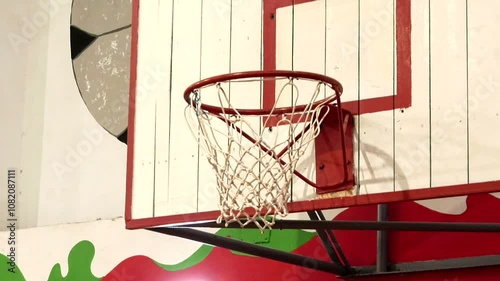 Basketball ball hitting hoop in gym close up