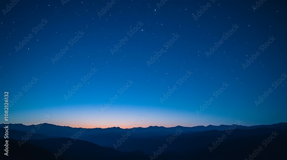 A vast night sky with a few stars and a faint sunrise over a mountain range. A vast night sky with a few stars and a faint sunrise over a mountain range.