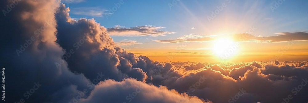Fototapeta premium Sunrise over fluffy clouds in a clear blue sky