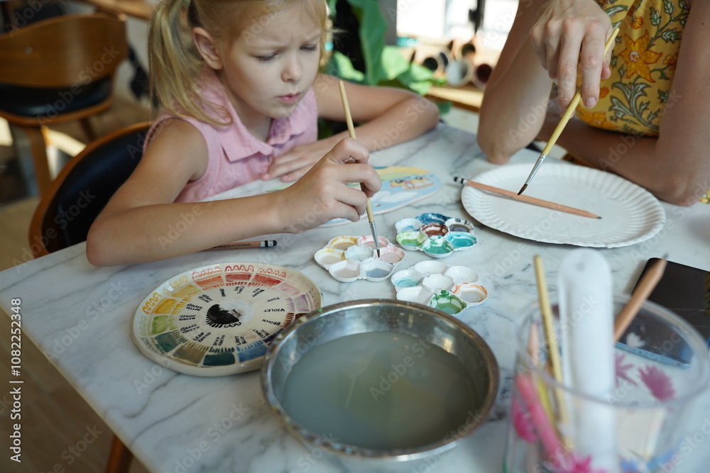 Fototapeta premium A young mother and her daughter enjoy a creative art session at home 