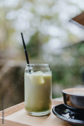 Japanese iced matcha latte, green tea with milk, soy milk, with straw in glass. Outdoor cafe