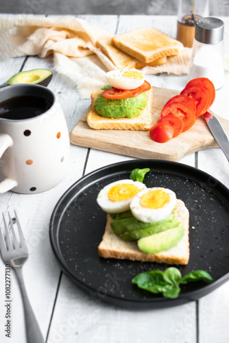 
Sandwiches with avocado, tomatoes and poached eggs. on a wooden backyard. Snidanok. photo