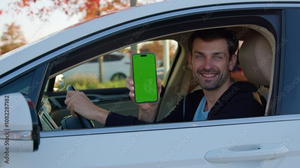 Happy man sits in auto showing car sharing app on phone Happy man sits in auto showing car sharing app on phone