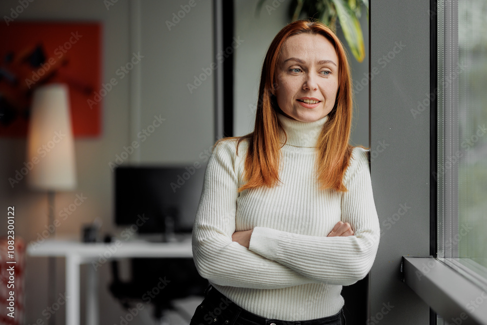 Content woman looks out office window Content woman looks out office window
