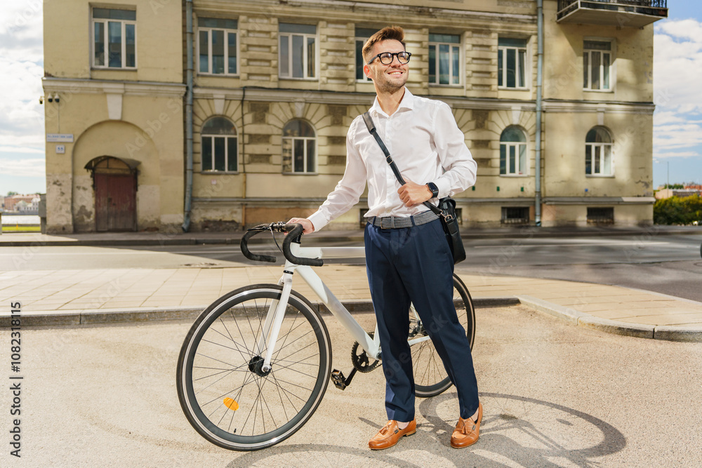 Fototapeta premium A Man in Formal Attire Stands Beside His Bicycle on an Urban Street During a Sunny Afternoon
