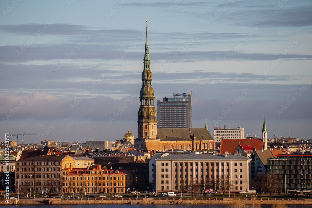 Obraz premium Riga, Latvia city skyline in late 2024 with could and warm light of river Daugava and buildings in city center and old town 