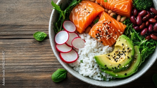 An artful arrangement of a poké bowl with fresh salmon, creamy avocado, radishes, rice, and an assortment of greens. A modern, healthy meal option captured lovingly. photo