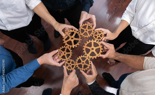 Business team joining cogwheel in circular together symbolize successful group of business partnership and strong collective unity teamwork in community workplace with productive efficiency. Prudent