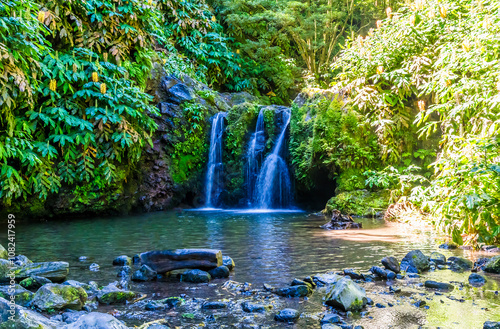 A long exposure view of a splash pool and waterfall at the Ribeiria waterfalls on the island of Sao Miguel in the Azores in summertime photo