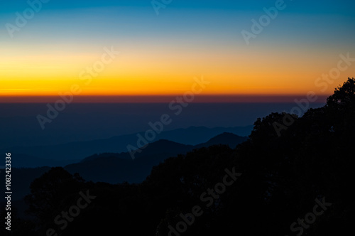 The beautiful sunrise at Doi intanon national park, Chiang Mai in the morning.Sun is rising from the hill to shy with beautiful yellow orange light. photo