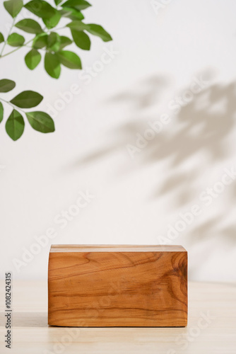 Wooden podium table top blurred green leaf plant on white empty space nature background.Beauty cosmetic natural product modern stage display.