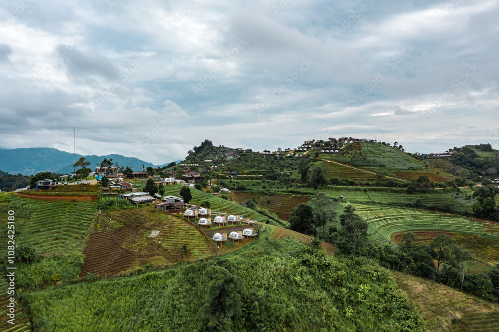 An aerial photographic view of Mon Jam Village in Chiangmai, filled with houses, resorts, and homestays for all the visitors. An aerial photographic view of Mon Jam Village in Chiangmai, filled with houses, resorts, and homestays for all the visitors.