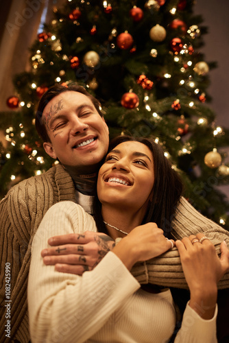 A loving couple enjoys a cozy moment together, surrounded by festive holiday decorations.