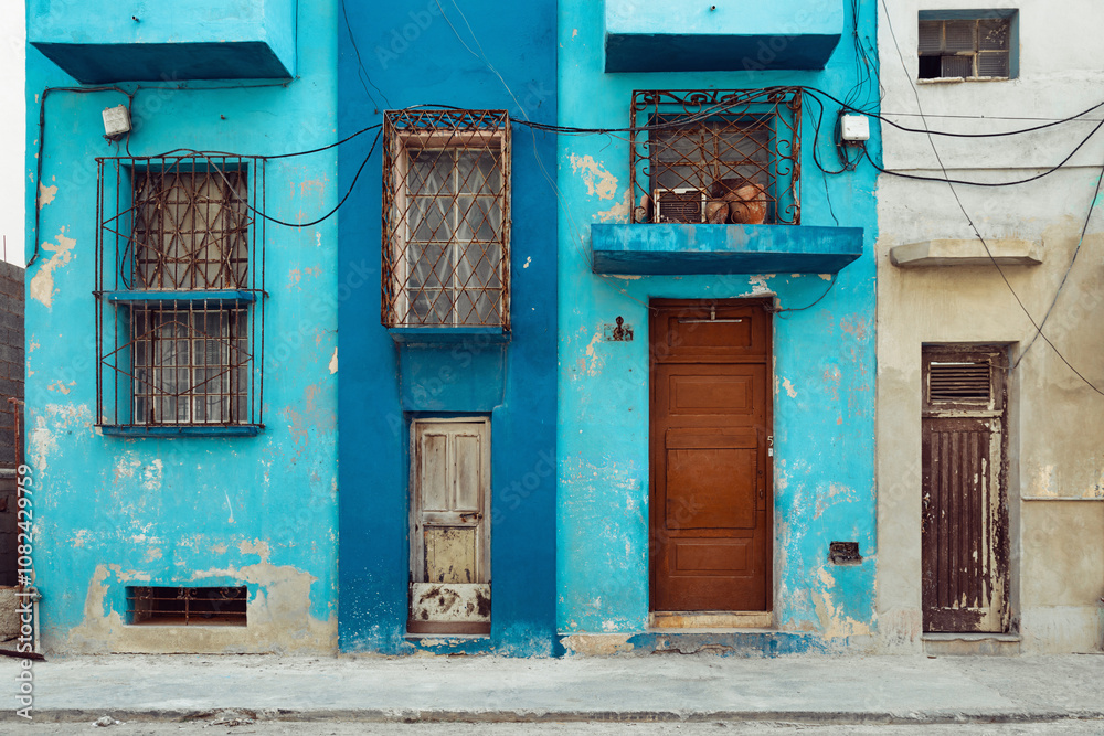 Rough painted facades of buildings with bars on the windows, Havana, Cuba