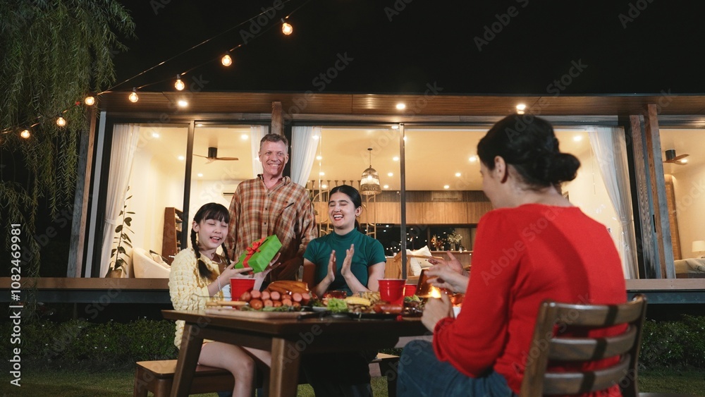 Naklejka premium Family together celebrate anniversary in garden. Senior give gift to granddaughter. Outdoor camping activity to relax with relatives, spend time with multigeneration cross generation gap. Divergence.