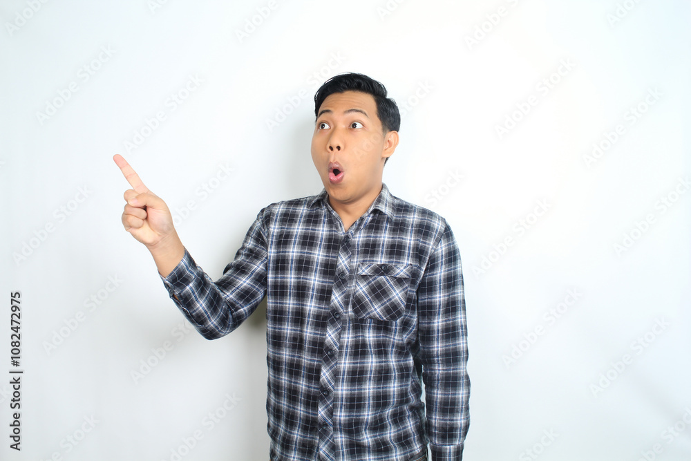 shocked asian man pointing hand with surprised funny expression isolated on white shocked asian man pointing hand with surprised funny expression isolated on white