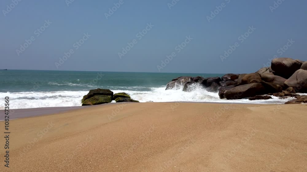 Ocean waves crash against rugged rocks on a tranquil, deserted beach, creating a serene and picturesque coastal scene Ocean waves crash against rugged rocks on a tranquil, deserted beach, creating a serene and picturesque coastal scene
