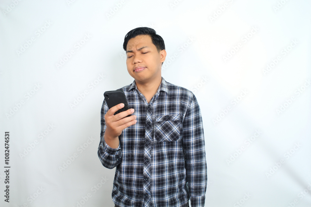 thoughtful asian man holding smartphone show confused face expression isolated on white background thoughtful asian man holding smartphone show confused face expression isolated on white background