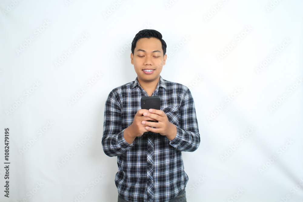 portrait of smiling asian man using smartphone wearing casual shirt isolated on white portrait of smiling asian man using smartphone wearing casual shirt isolated on white