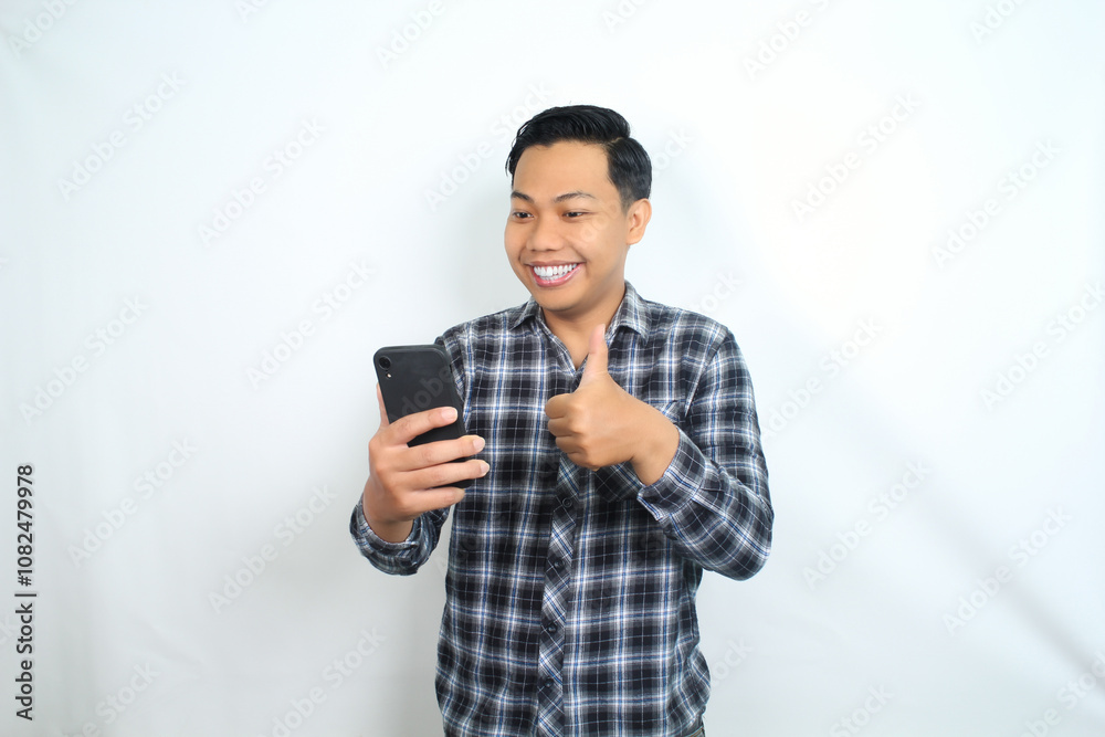smiling asian man showing thumb up with holding mobile phone wear casual shirt isolated on white smiling asian man showing thumb up with holding mobile phone wear casual shirt isolated on white