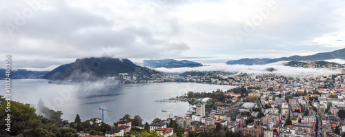 panoramic view of the lake and city of lugano on a cloudy day