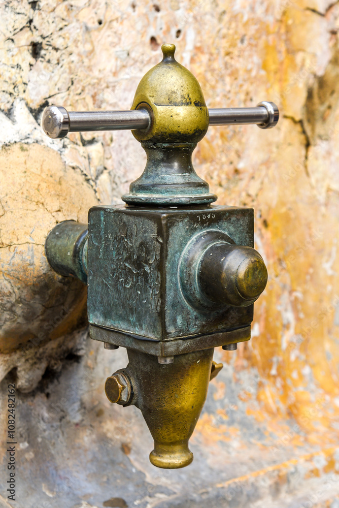 vintage street water faucet in a fountain in Tarragona, spain, made of metal