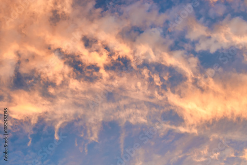 A beautiful sky tinted by the sun leaving vibrant shades of gold, pink, blue and multicolored. Clouds in the twilight evening and morning sky. Cloudy sky background in the evening, and during the day.