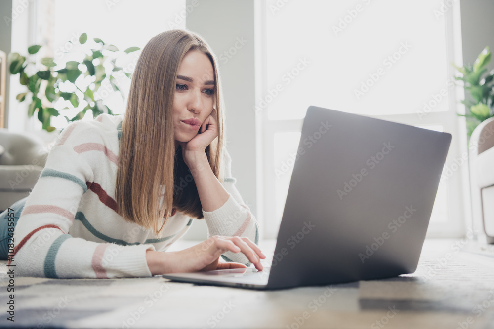 Young woman relaxing at home while using laptop, enjoying leisure time and connecting online during a cozy weekend indoors Young woman relaxing at home while using laptop, enjoying leisure time and connecting online during a cozy weekend indoors