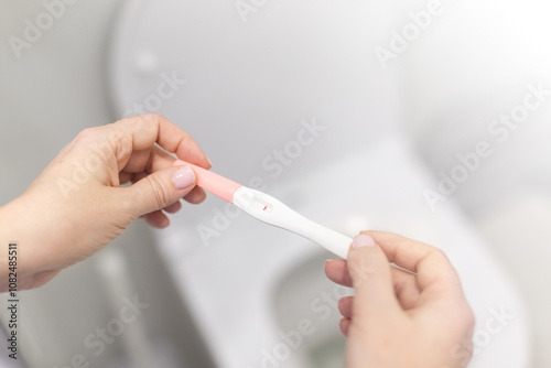 Holding positive pregnancy test in rest room