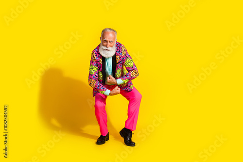 Full length photo of attractive retired man powerful show muscles dressed colorful pink fancy clothes isolated on yellow color background