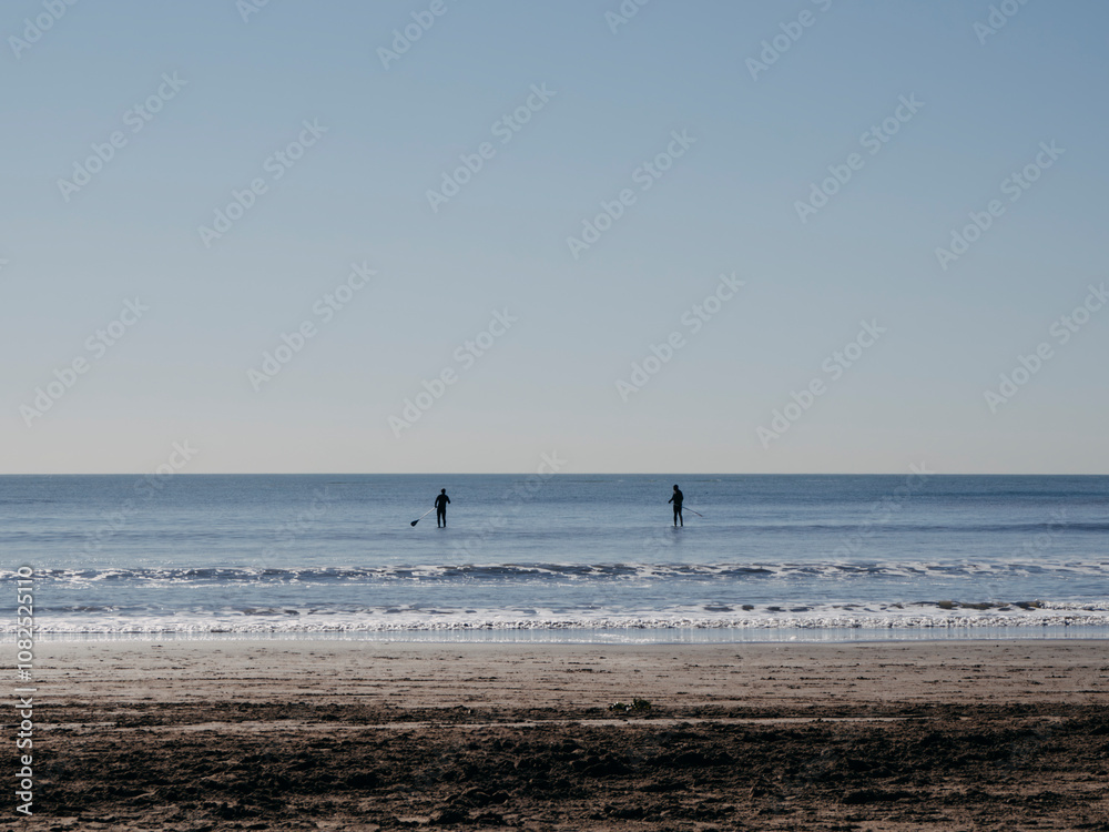 Dos personas practicando Stand Up Paddle en el mar Dos personas practicando Stand Up Paddle en el mar