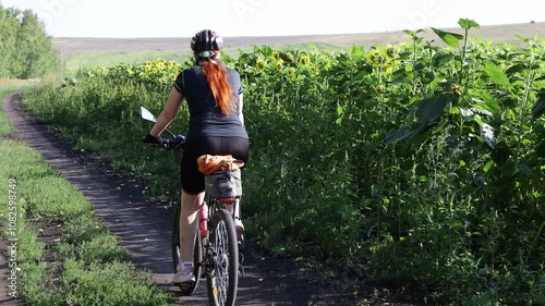 a female cyclist travels in nature , bikepacking and hiking on dirt roads