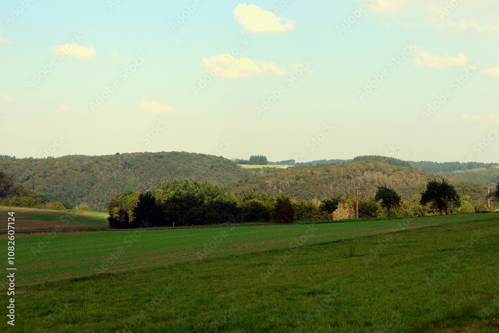 Hügelige Landschaft bei Kennfuss, nahe Bad Bertrich, in der Eifel im Landkreis Cochem-Zell. Aussicht vom Wanderweg Wasserfall-Erlebnisroute, der 2023 zu Deutschlands schönstem Wanderweg gewählt wurde. Hügelige Landschaft bei Kennfuss, nahe Bad Bertrich, in der Eifel im Landkreis Cochem-Zell. Aussicht vom Wanderweg Wasserfall-Erlebnisroute, der 2023 zu Deutschlands schönstem Wanderweg gewählt wurde.