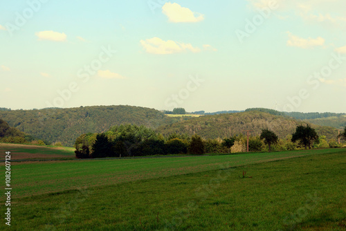 Hügelige Landschaft bei Kennfuss, nahe Bad Bertrich, in der Eifel im Landkreis Cochem-Zell. Aussicht vom Wanderweg Wasserfall-Erlebnisroute, der 2023 zu Deutschlands schönstem Wanderweg gewählt wurde. photo