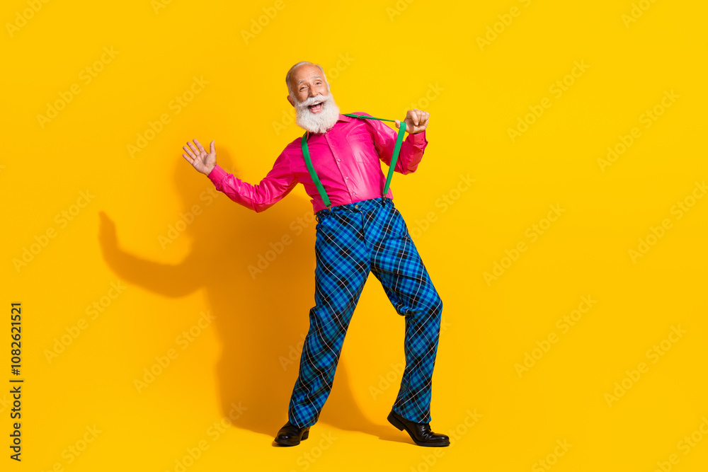 Full size photo of old gentleman cheerful pull suspenders dressed glamour stylish outfit party isolated vibrant yellow color background Full size photo of old gentleman cheerful pull suspenders dressed glamour stylish outfit party isolated vibrant yellow color background