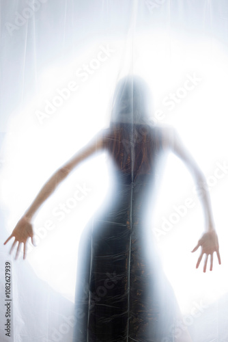 Mysterious Woman Behind Frosted Plastic Sheet in Abstract Studio Setting