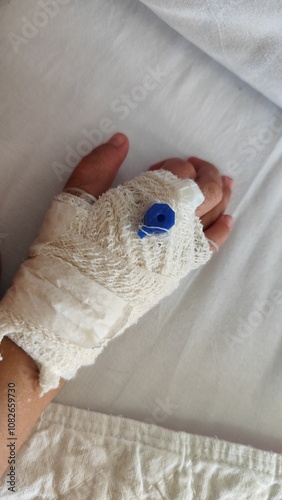 close up focus of kids hand wrapped with bandage and branula photo