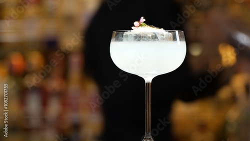 Closeup hand bartender using strainer in vodka coconut smooth fizzy cocktail at luxurious counter preparation making special to guest at fronted bar. Special refresh showcasing nightlife. Vinosity. photo