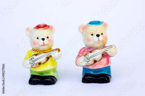 2 pepper shakers made of porcelain. This pepper shakers are in the shape of a pair of cute bears playing the guitar. photo