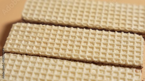 Waffles rotating on orange background. Chocolate waffles close-up on orange background.