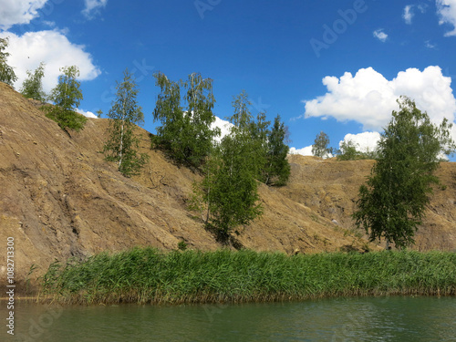 rocks with rare trees and crystal blue water in the Konduki quarry, Tula region, Russia