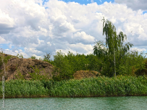 rocks with rare trees and crystal blue water in the Konduki quarry, Tula region, Russia