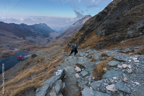 Woman with camera hiking on a trail in the mountains