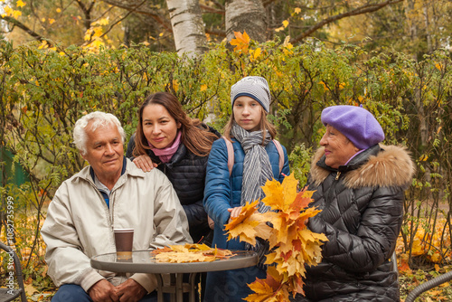 Happy family in park in autumn, portrait