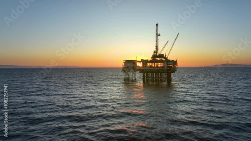 Aerial shot of an offshore oil platform at sunset