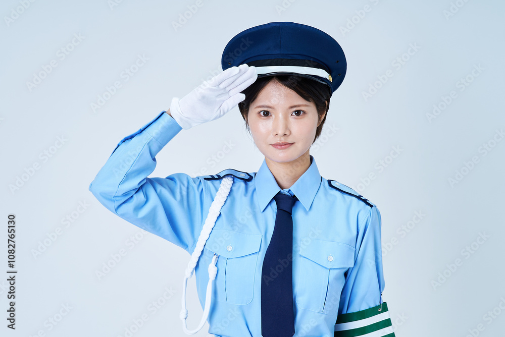 警備員の制服を着て、敬礼をする女性 警備員の制服を着て、敬礼をする女性