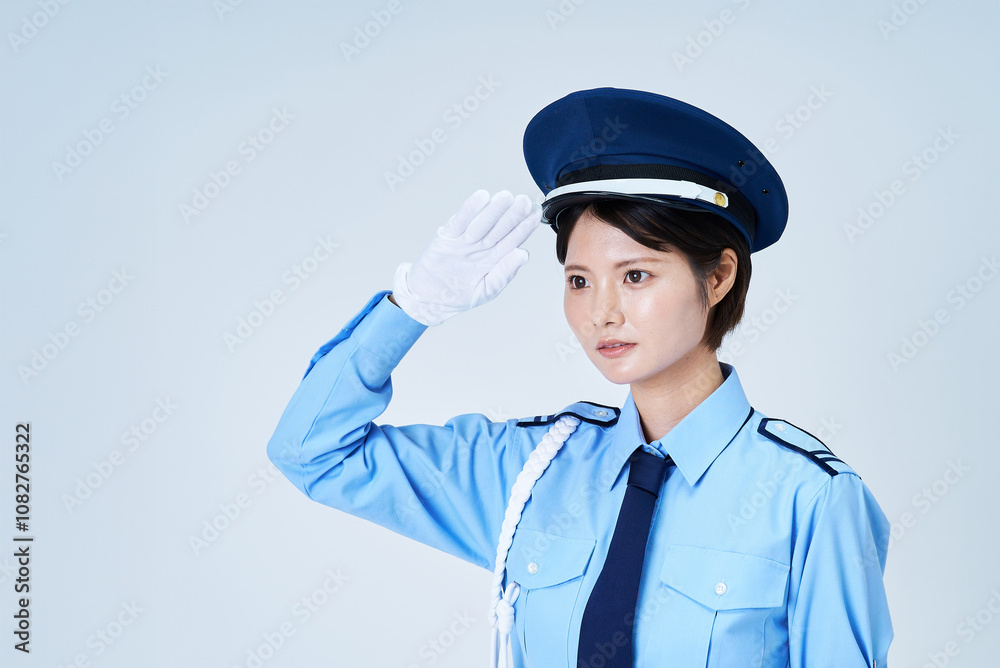 警備員の制服を着て、敬礼をする女性 警備員の制服を着て、敬礼をする女性