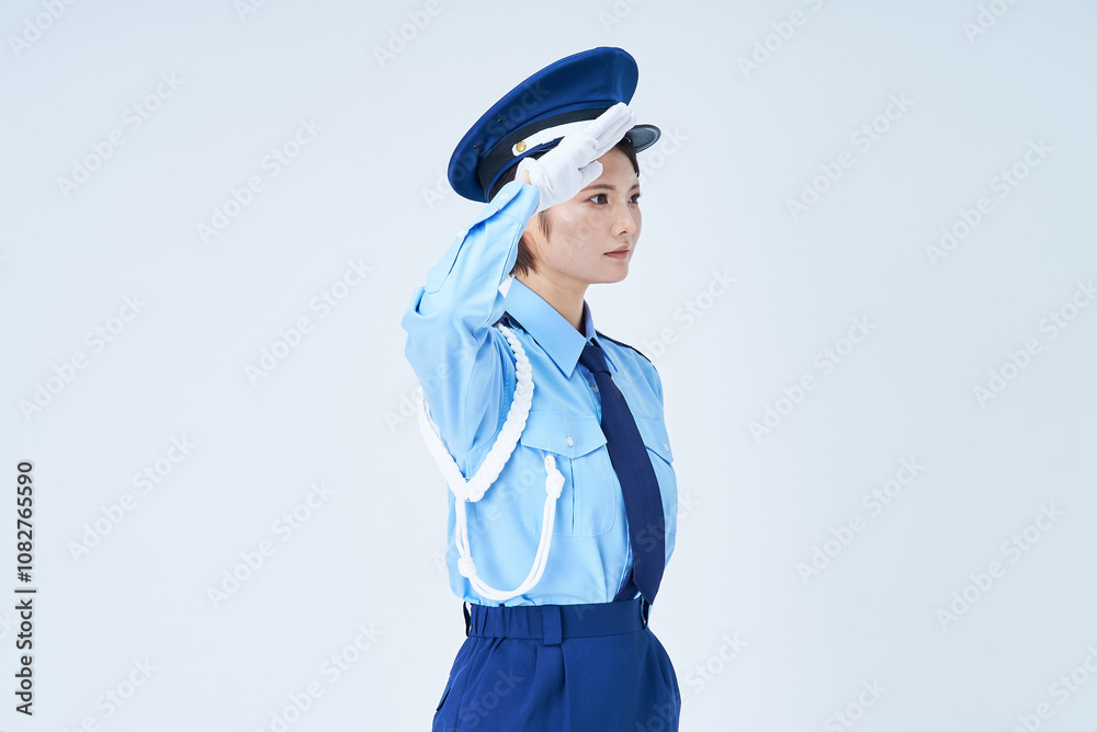 警備員の制服を着て、敬礼をする女性 警備員の制服を着て、敬礼をする女性