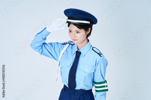 警備員の制服を着て、敬礼をする女性