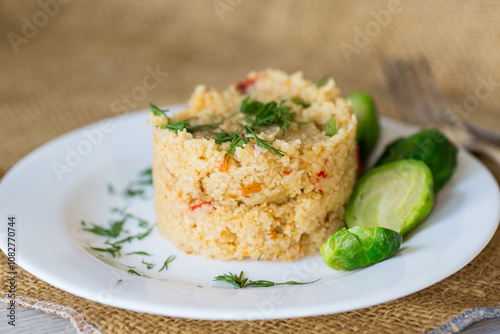 homemade cooked bulgur with Brussel sprouts in a plate, on a wooden table